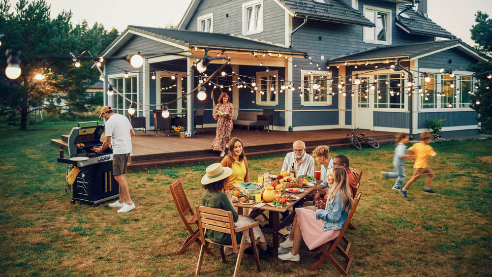 family and friends sitting at table outside having dinner